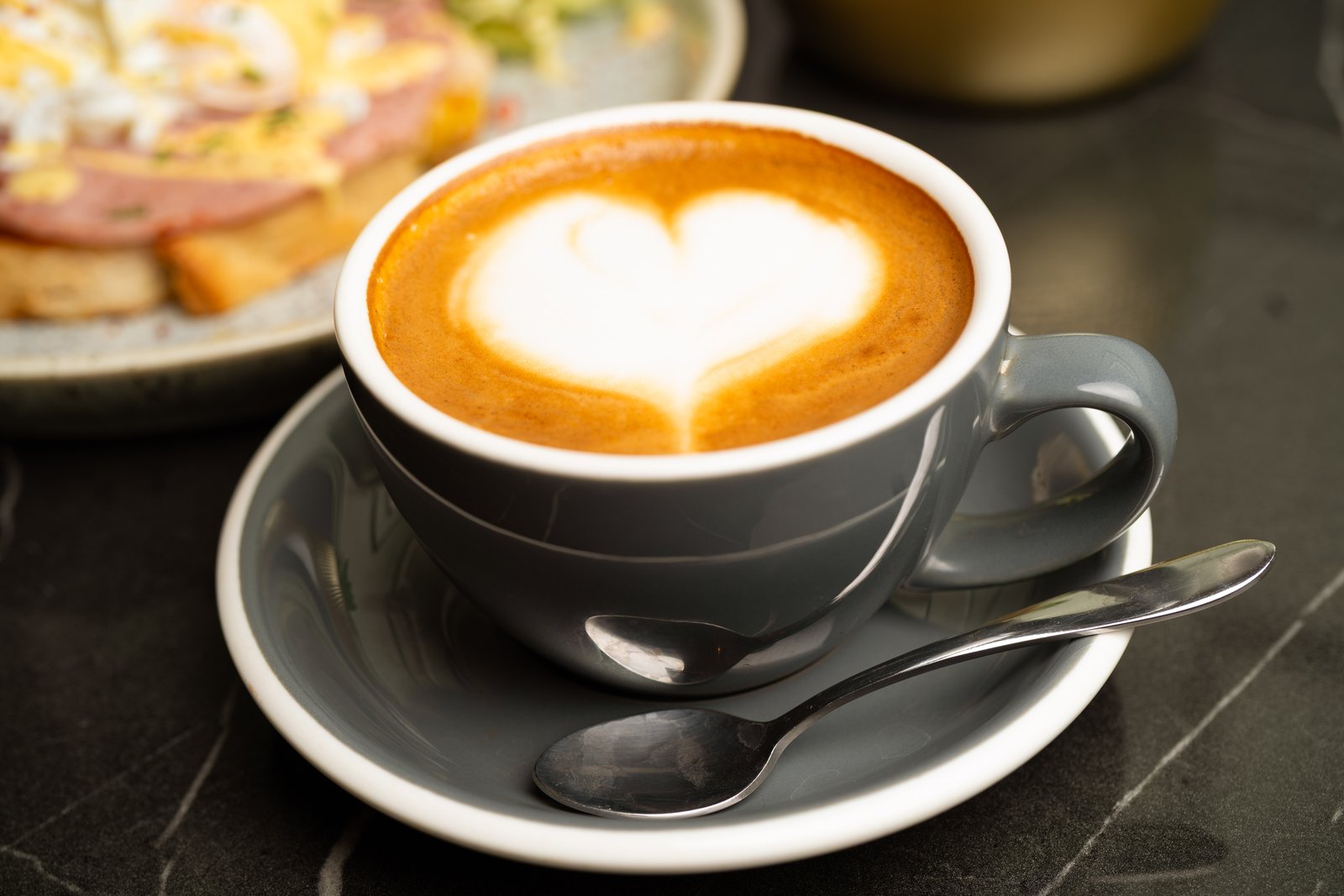 Specialty latte with fresh leaf art in a warm ceramic cup